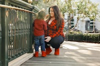 a woman and a child standing on a railing